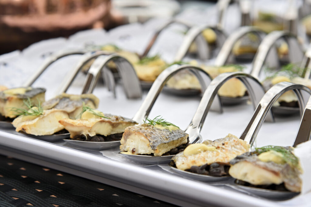 Detailaufnahme eines Verzehrlöffels mit einem angebratenem Filetstück vom Fisch