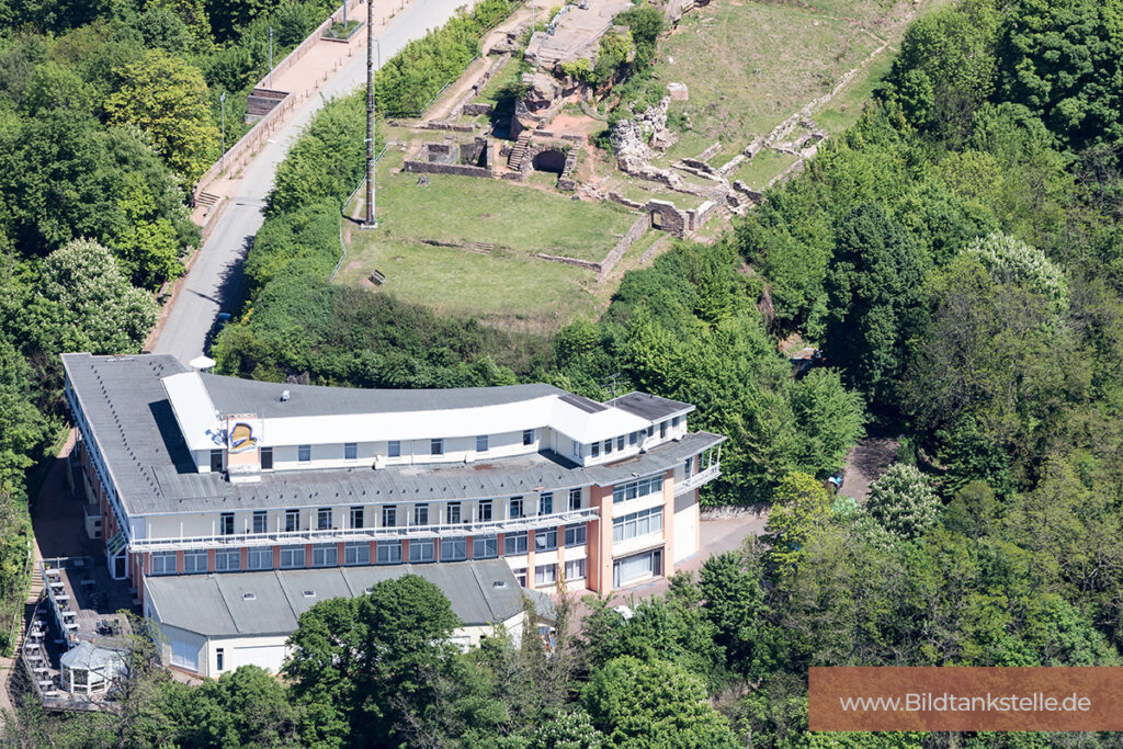 Das Schlossberg Hotel von oben mit Ruine im Hintergrund und Wald drumherum